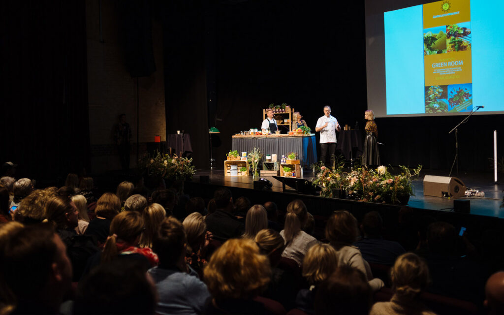 Alain talar på scenen inför publiken.