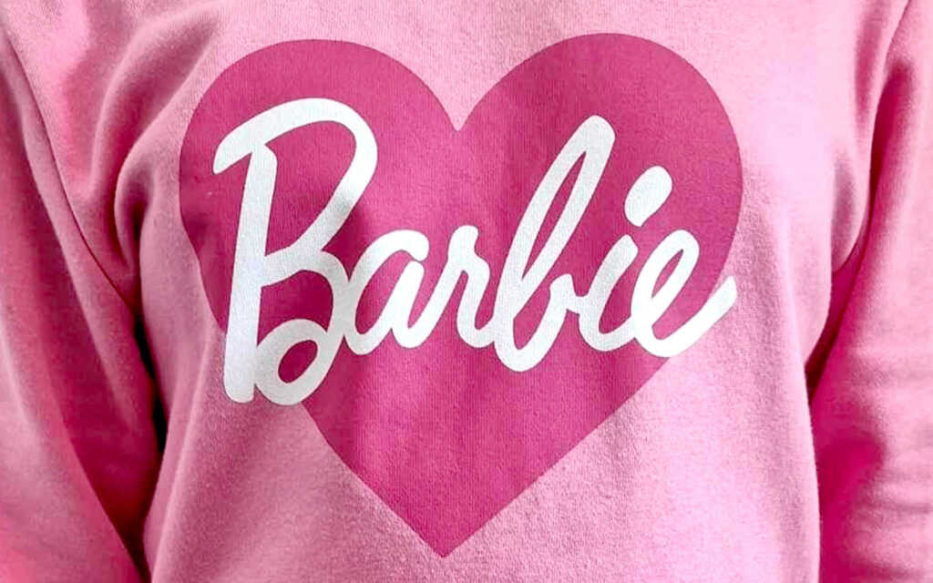 Närbild på rosa tröja med ett stort hjärta som det står Barbie i.