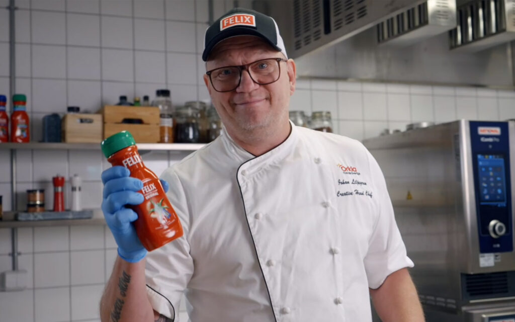 Kocken Johan Liljegren håller i en flaska med Felix Tomatketchup.