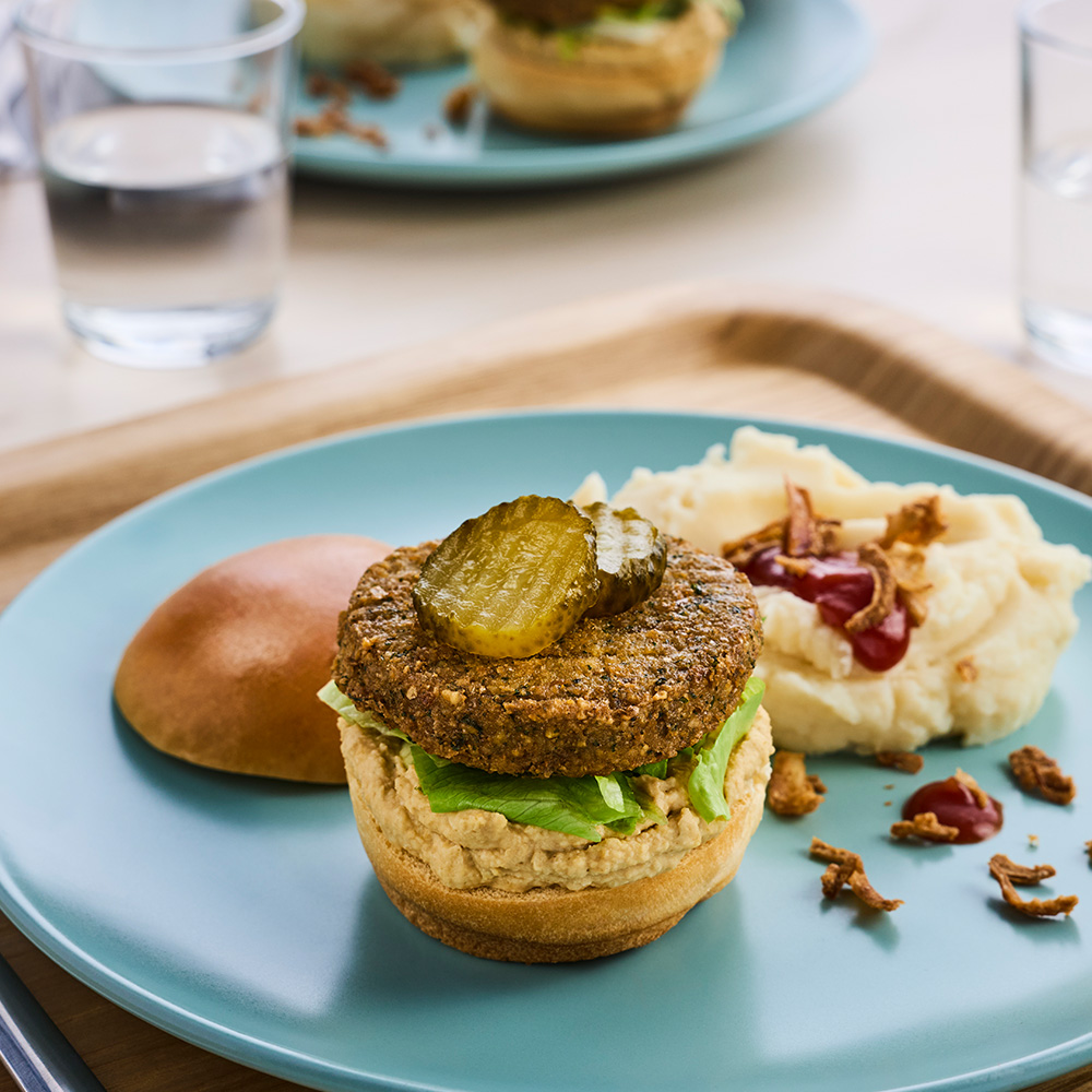 Burgare gjord på Lecora Falafel Burger Eko, serverad med toppings och bröd.